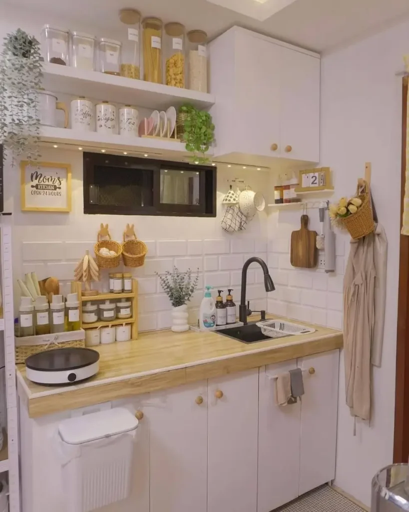 A tiny kitchen idea with white cabinets, wood countertops, and extensive wall storage.