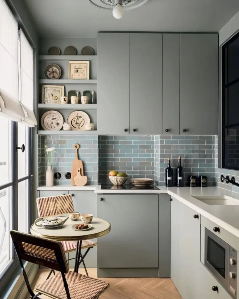 A small kitchen design idea with sage green cabinets and a blue tile backsplash.