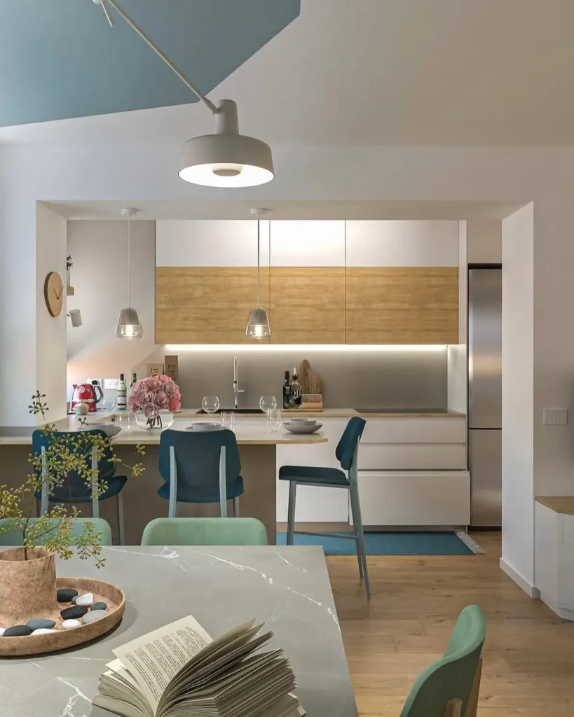 A small kitchen design idea using two-tone white and wood cabinets in an open-plan layout.
