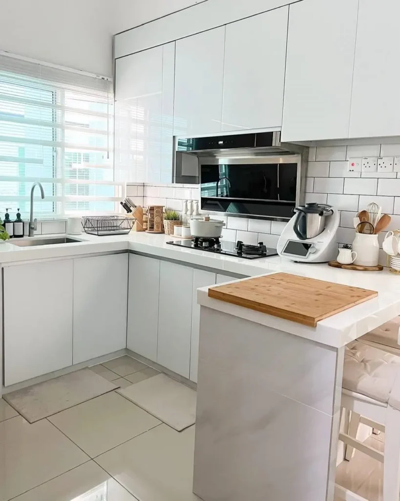 A modern all-white kitchen with high-gloss handleless cabinets and a subway tile backsplash.
