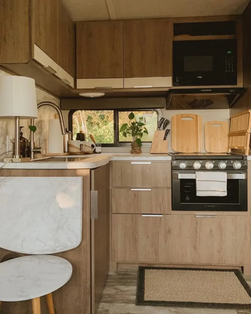 A compact kitchen featuring warm wood-grain cabinets and a small breakfast bar.