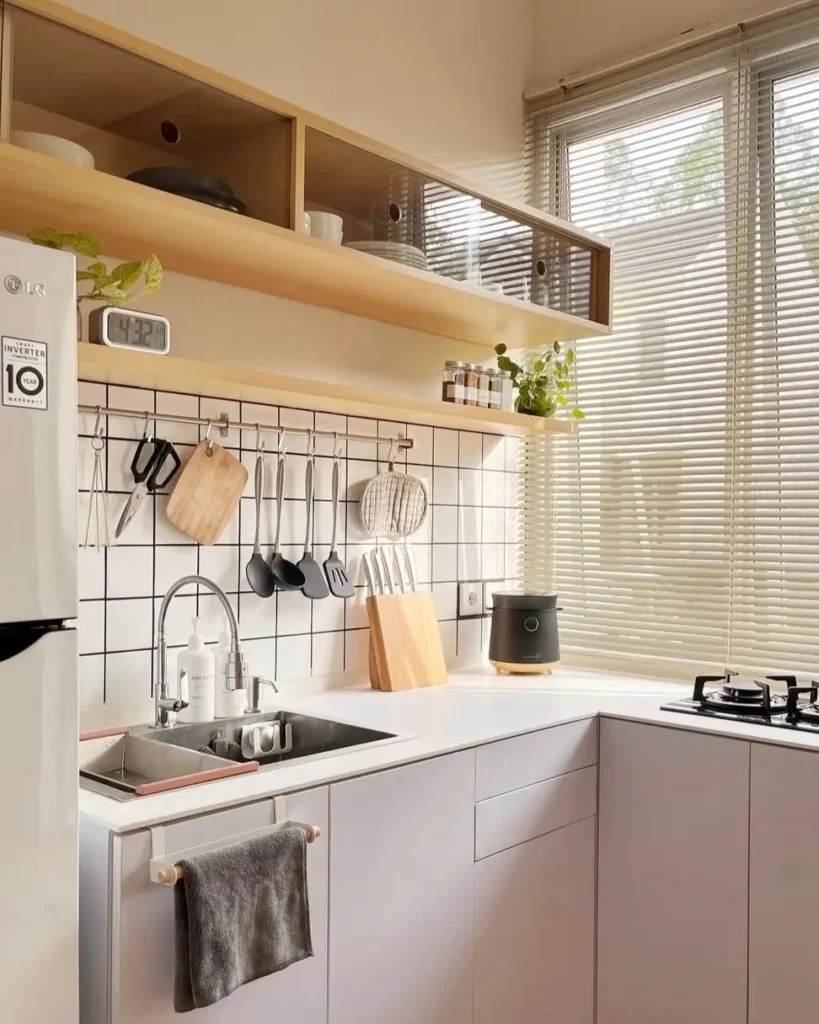 A modern small kitchen with light wood open shelves and white handleless cabinets.