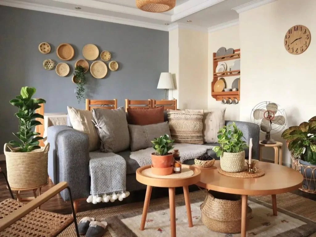 A cozy living room with a gray accent wall adorned with woven baskets, a gray sofa, and natural wood furniture.