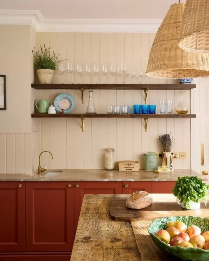 A simple rustic kitchen idea with deep earthy red cabinets, open wood shelving, and a large woven pendant light.