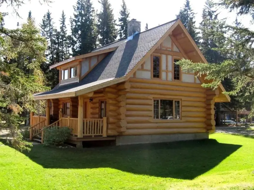 60 Charming Small Log Cabin Ideas to Inspire Your Rustic Retreat 13 A small log cabin home with rounded logs on the first floor and light-colored siding on the second floor.