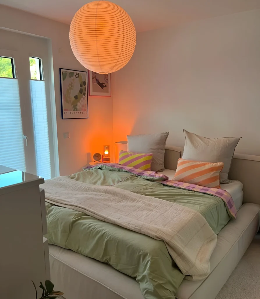 Bedroom with colorful pillows and warm lighting.