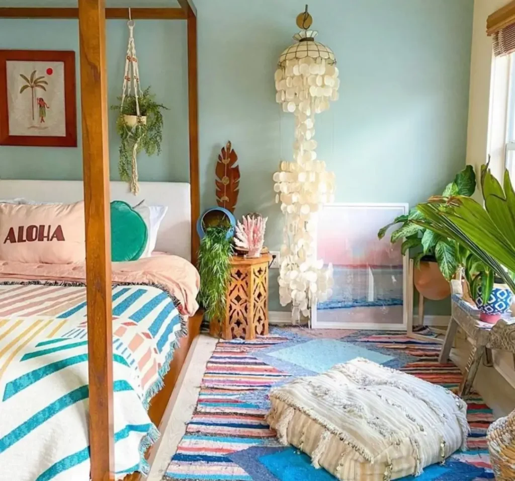 A boho-style bedroom featuring light green walls, a wooden four-poster bed, and framed tropical wall art.