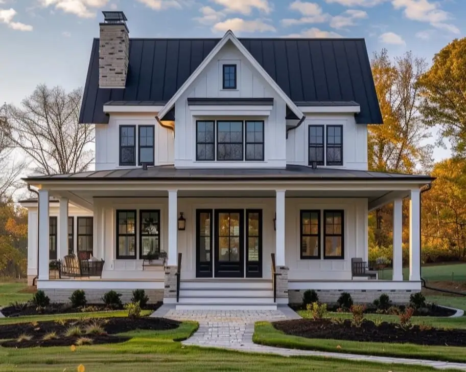 A symmetrical modern white farmhouse with a black standing-seam metal roof, black-framed windows, and a central black double-glass front door.