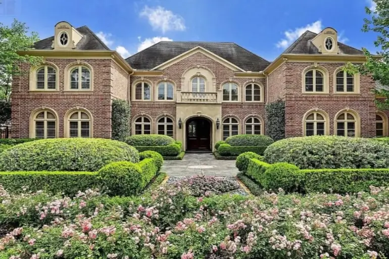 The Ultimate Guide to Luxury Mansion Design: 33 Ideas for Grandeur 15 A classic red brick mansion with formal manicured flower gardens in the foreground.