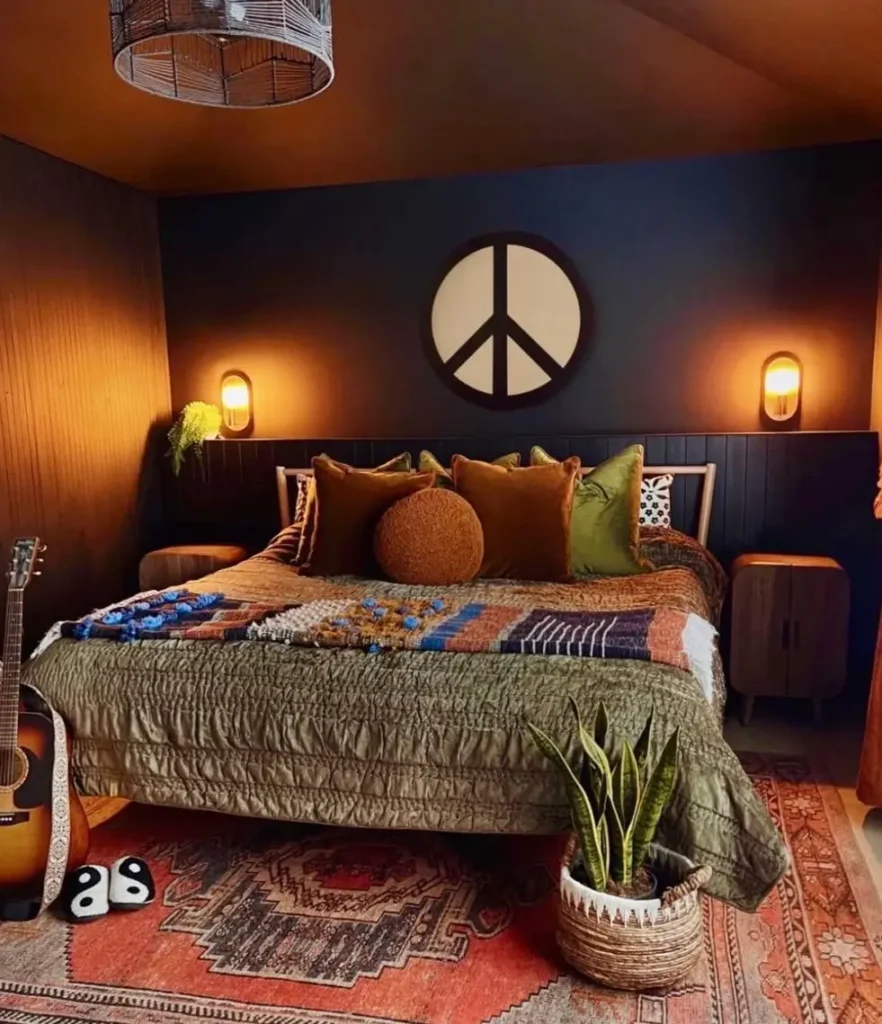 A moody boho bedroom with dark walls, featuring a large white peace sign above the bed and warm accent lighting.