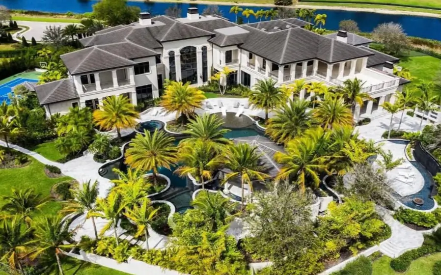 The Ultimate Guide to Luxury Mansion Design: 33 Ideas for Grandeur 17 An aerial view of a modern mansion with a resort-style pool and lush tropical landscaping.