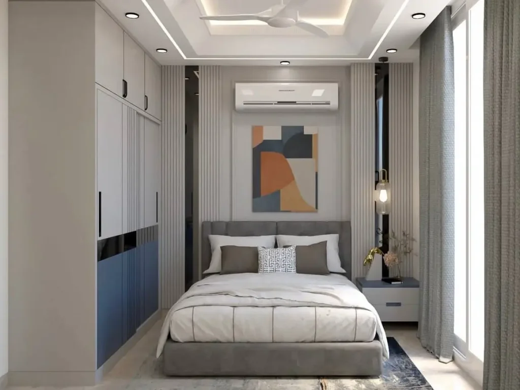 A modern small bedroom interior design with grey and blue built-in wardrobes, a slatted feature wall, and integrated ceiling lighting.