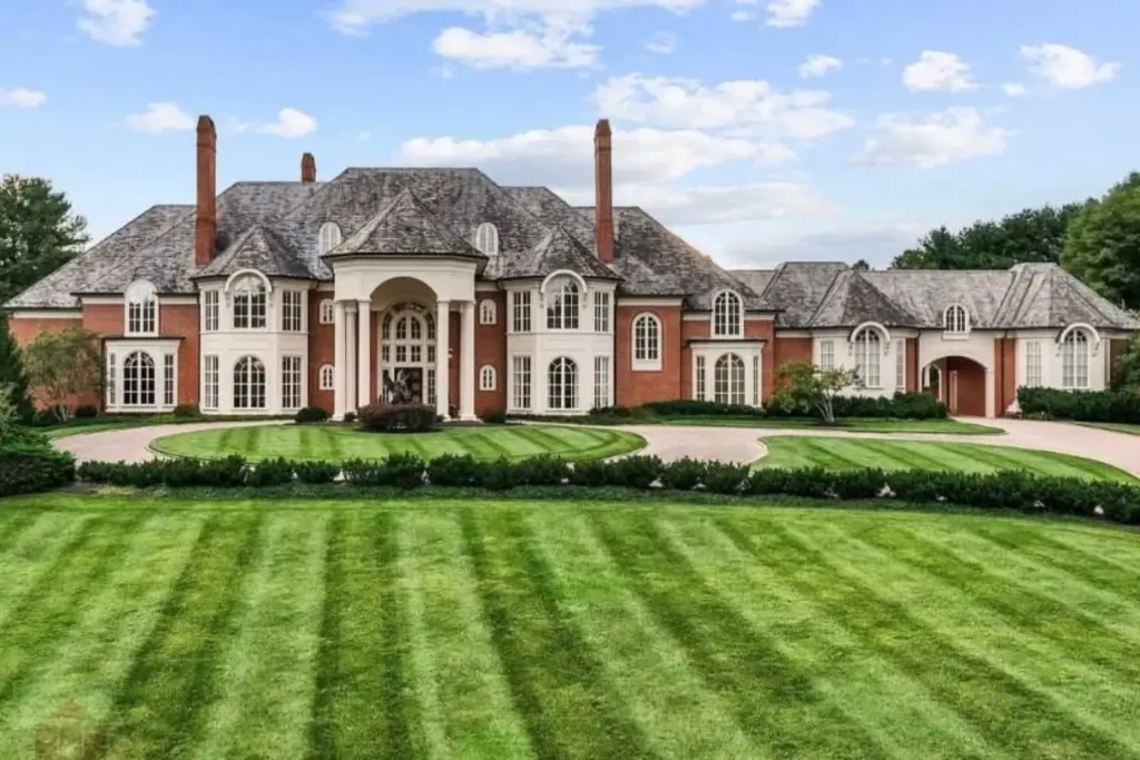 The Ultimate Guide to Luxury Mansion Design: 33 Ideas for Grandeur 18 A classic red brick mansion with a sweeping, perfectly manicured lawn and circular drive.