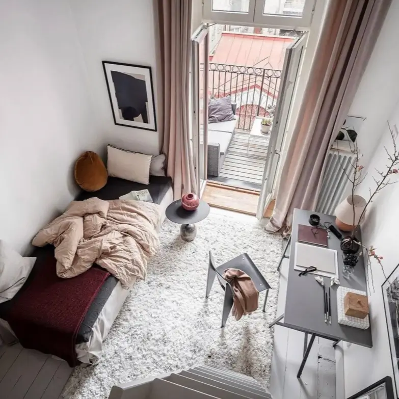 A small cozy bedroom design idea with a daybed, a separate slim desk for a workspace, and a door leading to a balcony.