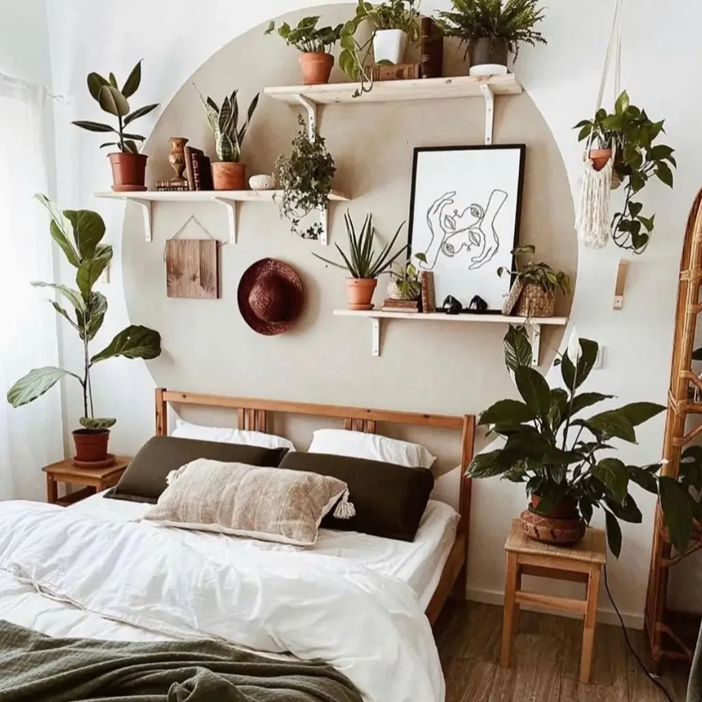 A painted arch on the wall behind a bed, with white shelves inside holding numerous plants and decor items in a boho bedroom.