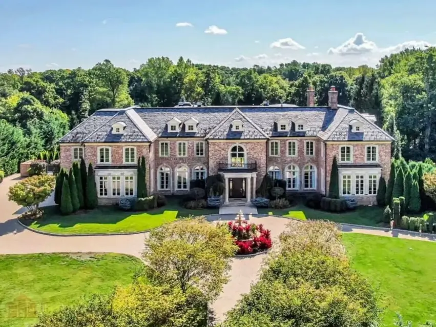 The Ultimate Guide to Luxury Mansion Design: 33 Ideas for Grandeur 22 An aerial view of a classic brick mansion nestled in a secluded, wooded estate.