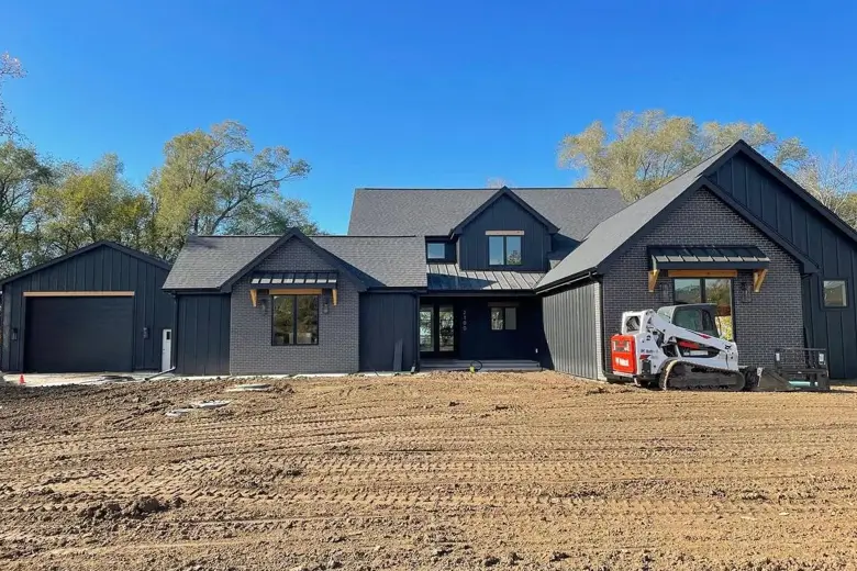 A modern black house exterior featuring a blend of dark brick and vertical siding for a rich, textured appearance.