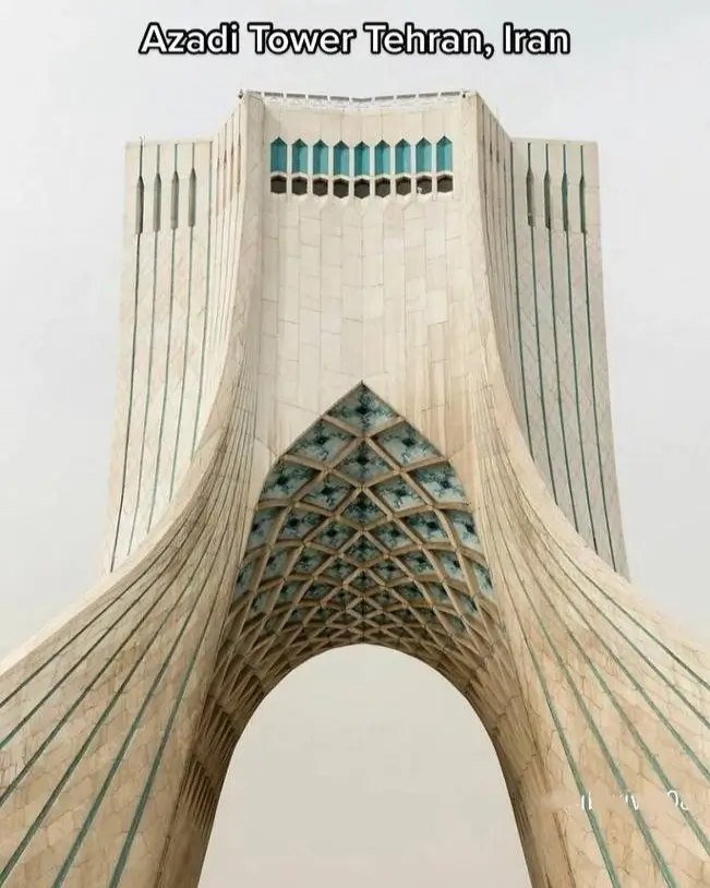 A monumental white archway, an architectural idea featuring intricate blue geometric patterns on its interior.