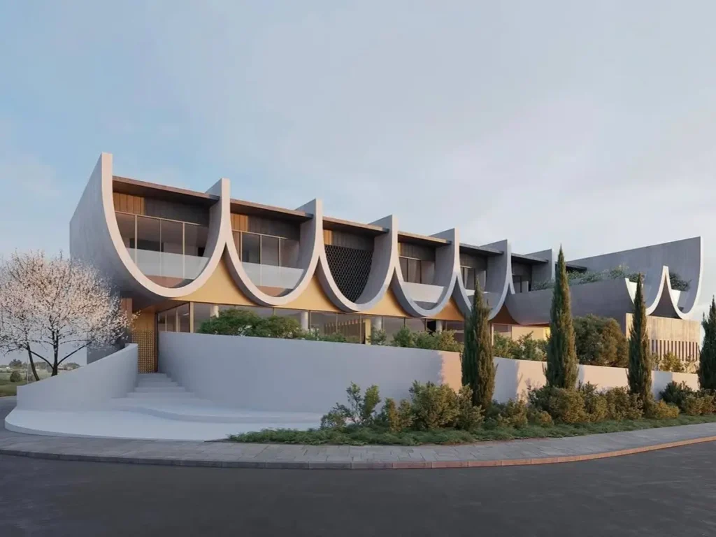 A modern concrete building with a unique rhythmic facade of repeating scalloped arches.