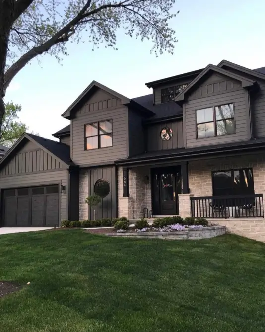 A modern dark house exterior featuring unique circular and geometric windows as personality-filled architectural details.