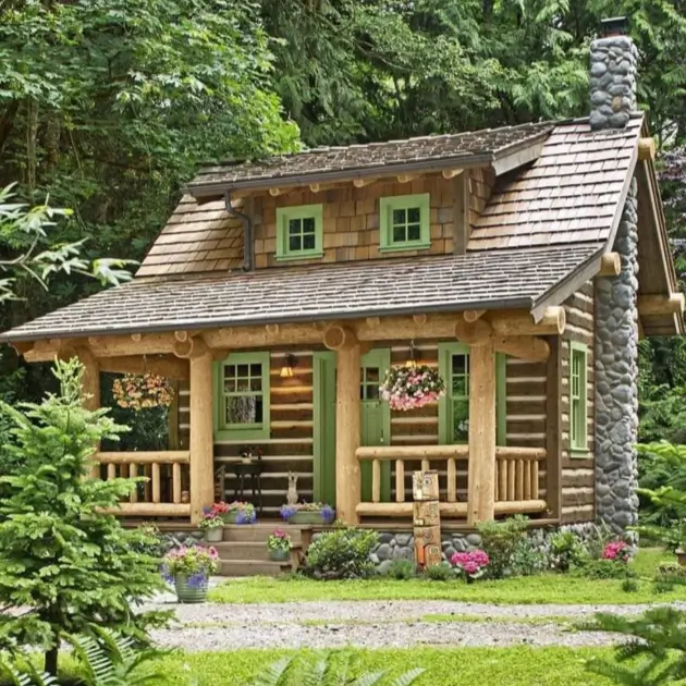 60 Charming Small Log Cabin Ideas to Inspire Your Rustic Retreat 30 A charming small log cabin with a stone chimney and green trim, nestled in a forest setting.