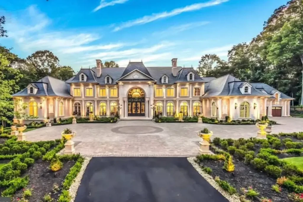 The Ultimate Guide to Luxury Mansion Design: 33 Ideas for Grandeur 6 A sprawling French-style luxury mansion with a grand motor court at dusk.