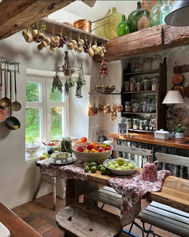 A charming rustic kitchen with dried herbs and produce hanging over a wooden table, showcasing functional decor.