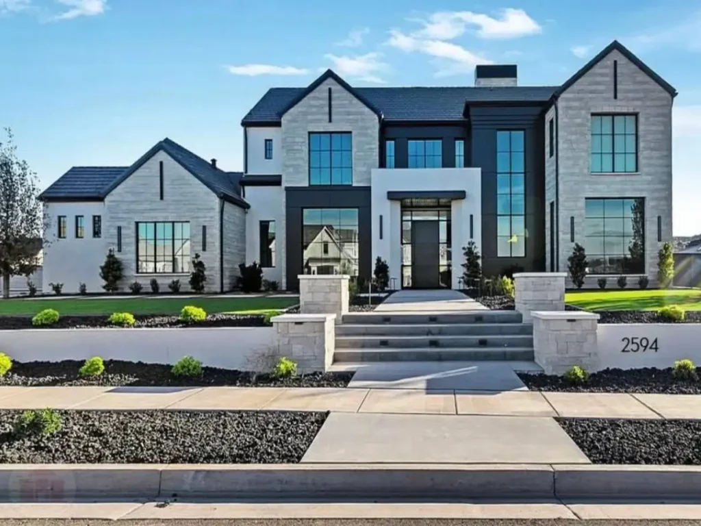 The Ultimate Guide to Luxury Mansion Design: 33 Ideas for Grandeur 33 A modern mansion with a high-contrast facade of light stone and dark panels.