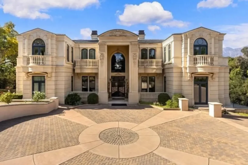 The Ultimate Guide to Luxury Mansion Design: 33 Ideas for Grandeur 36 A grand, symmetrical luxury mansion with a central arched entrance and dual balconies.