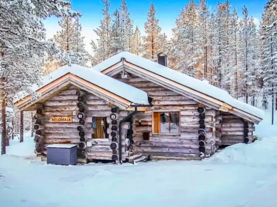Small Log Cabins: 36 Ideas for Cozy Living & Enduring Charm 39 A weathered small log cabin with interlocking roofs, covered in deep snow in a winter forest.