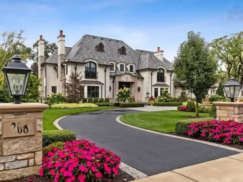 The Ultimate Guide to Luxury Mansion Design: 33 Ideas for Grandeur 8 A French country style home with a winding driveway and stone entry pillars.