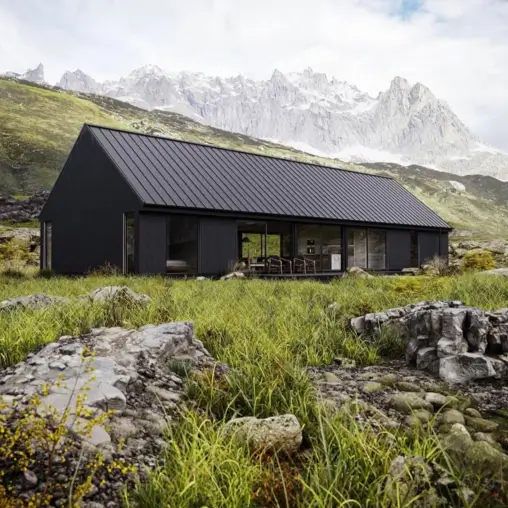 A minimalist black house with a metal roof and large windows, serving as a modern shelter in a vast mountain landscape.
