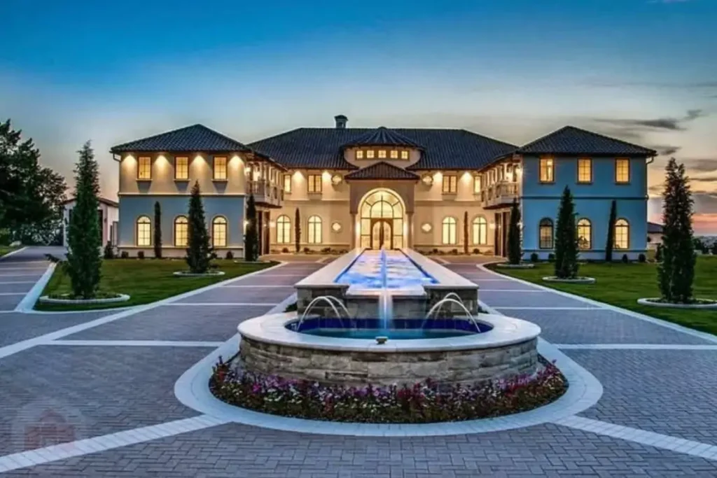 The Ultimate Guide to Luxury Mansion Design: 33 Ideas for Grandeur 9 A modern mansion with a long, illuminated water fountain leading to the grand entrance.