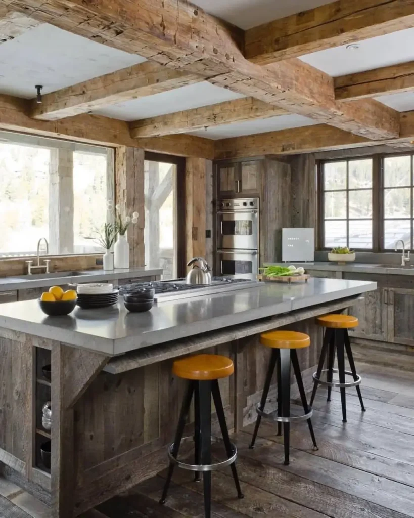 A modern rustic kitchen with reclaimed wood cabinets, exposed beams, and a large island with a polished concrete countertop.