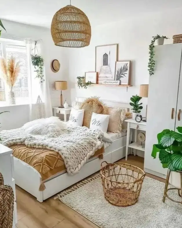 A bright, cozy bedroom with a large, chunky cream-colored knit blanket layered on the bed.