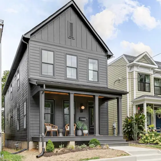 A cohesive black house design with a dark, sheltered front porch that creates a moody and sophisticated entrance.