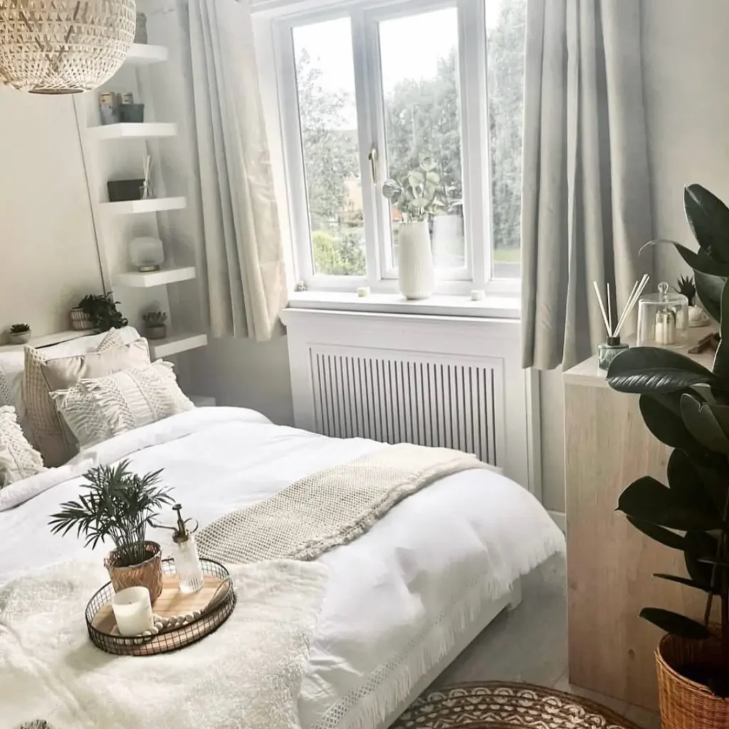 A serene, neutral-toned bedroom with white bedding, a wicker pendant light, and layers of soft, natural textures.