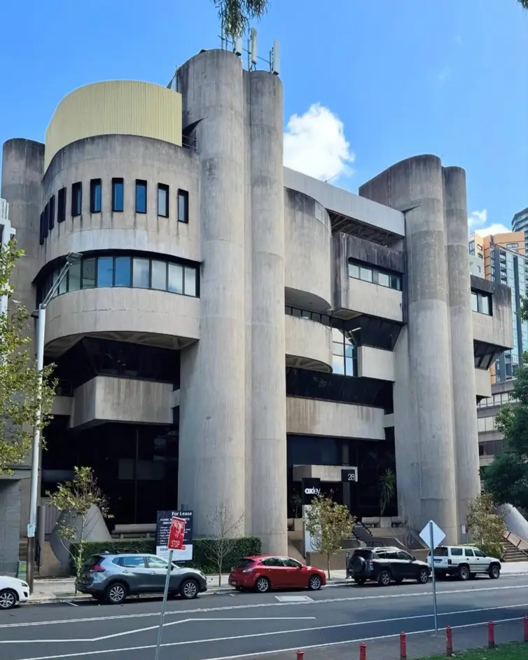 A classic example of Brutalist architecture design, showing a building with massive, textured raw concrete columns and a block-like form.