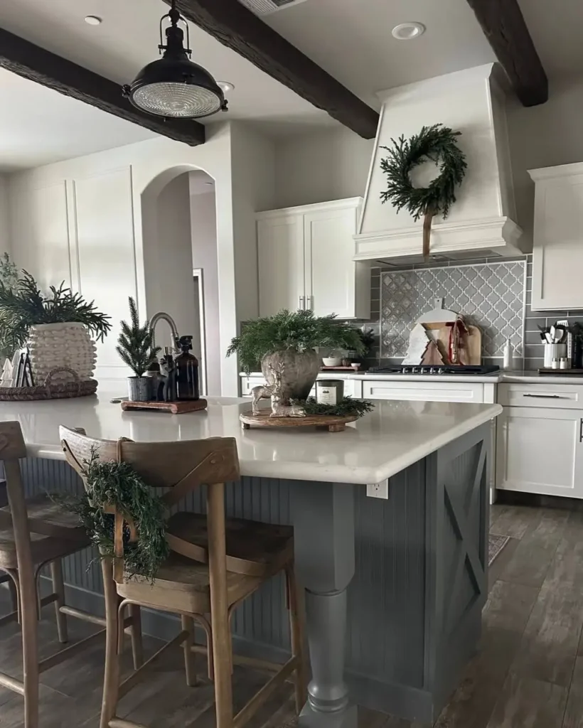 Modern farmhouse kitchen with a gray island, dark wood beams, and a patterned tile backsplash.