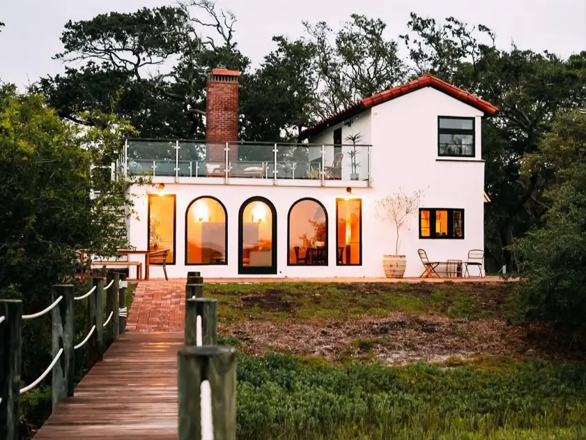 A stunning 1930s Spanish-style villa in St. Augustine with arched windows, a red tile roof, and a rooftop terrace overlooking the marsh.