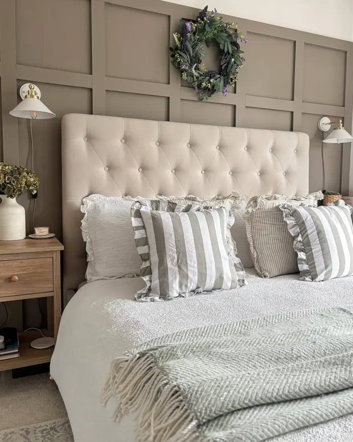 Modern farmhouse bedroom with a taupe board and batten accent wall, tufted headboard, and striped pillows.