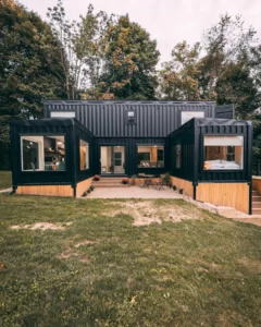 Black shipping container home with a U-shaped design and central courtyard.