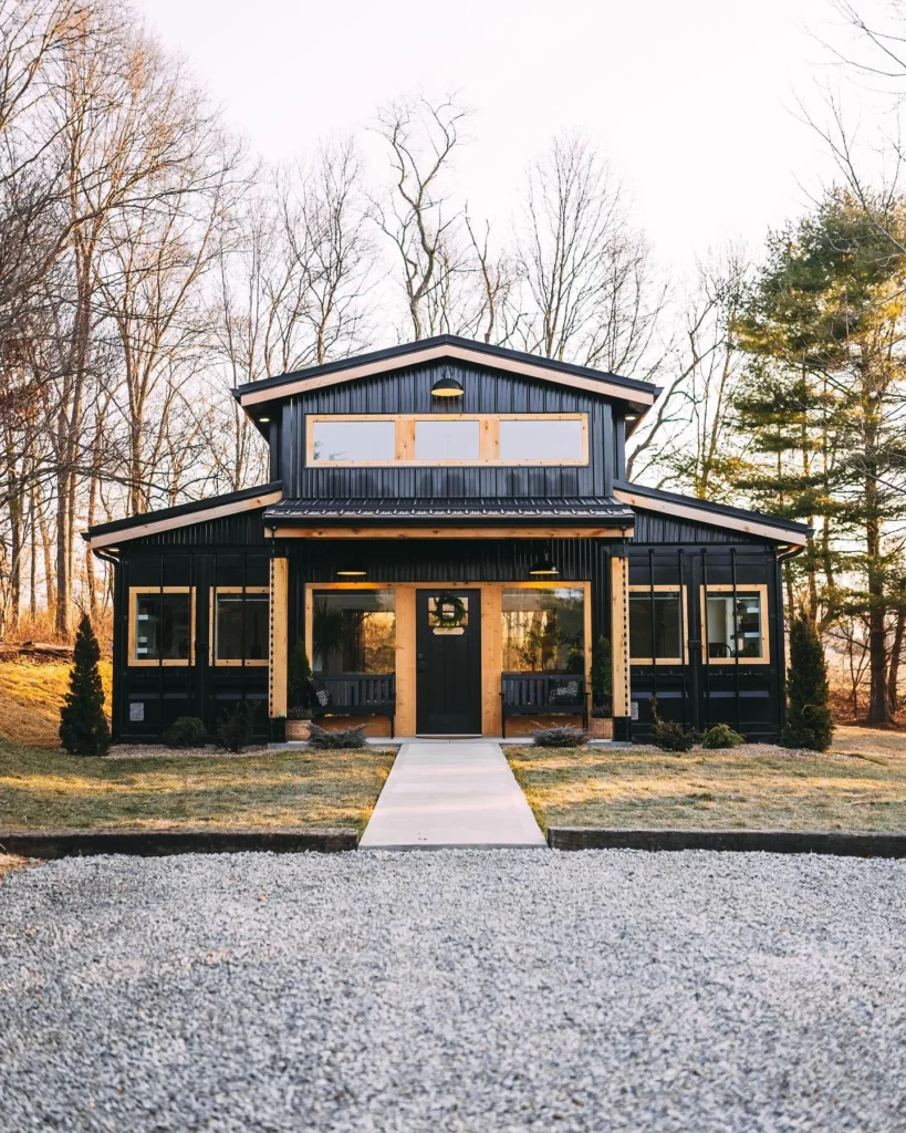 Shipping container home with a gambrel roof, resembling a modern barn.