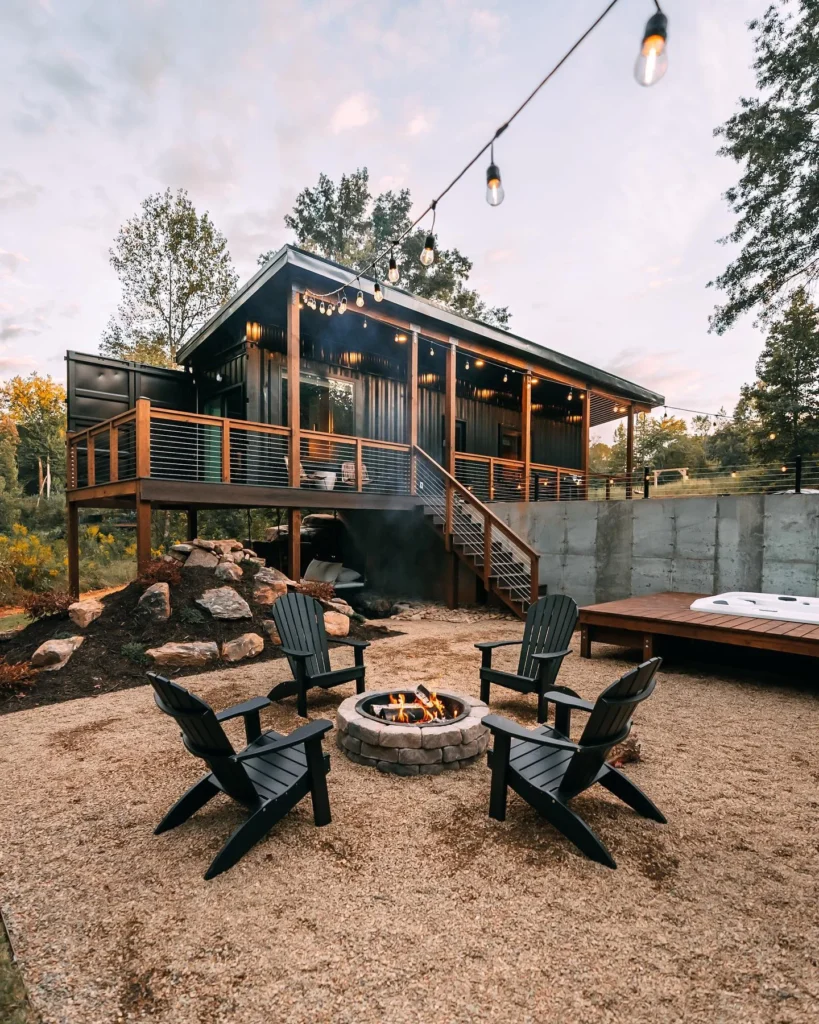 Shipping container home with large deck, fire pit, and outdoor seating area.