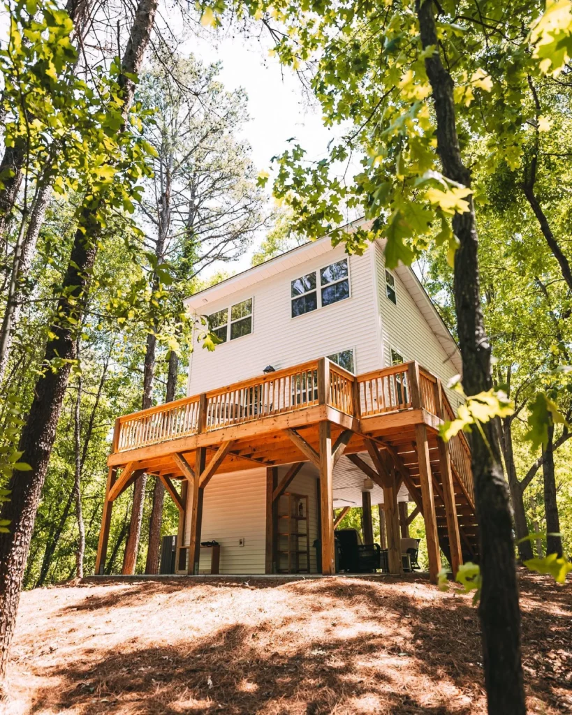 Elevated treehouse-style stunning house design with wrap-around deck.