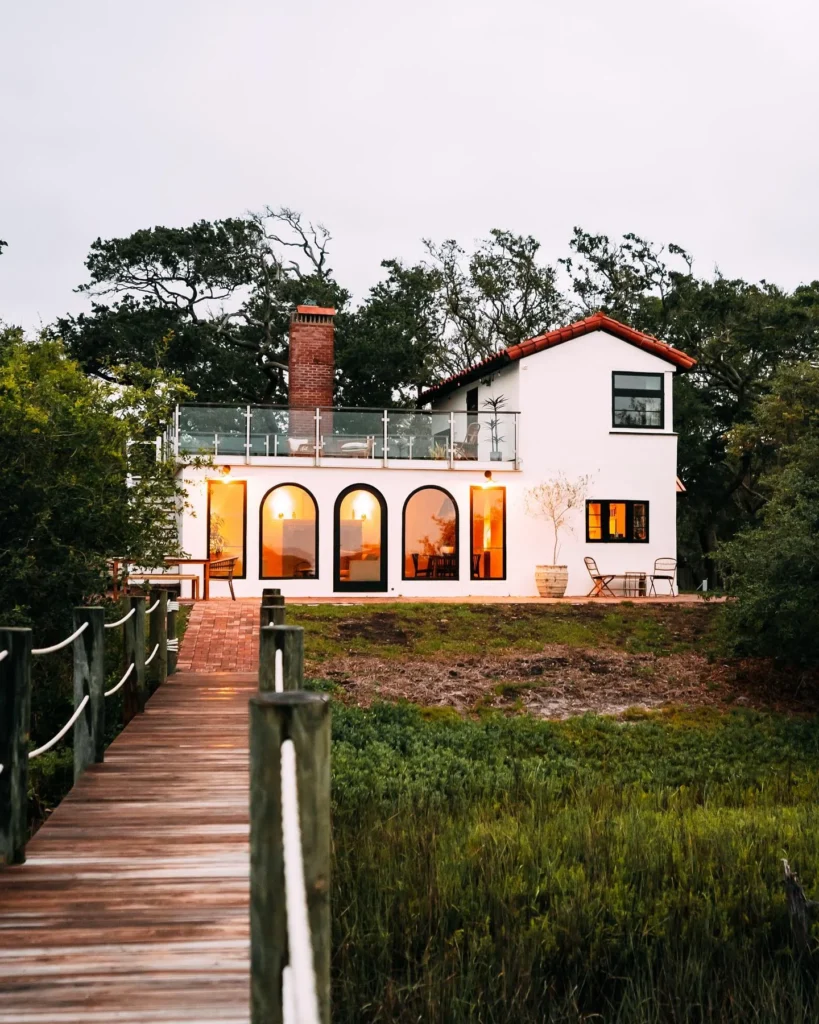 Stunning house design with arched windows and waterfront view.