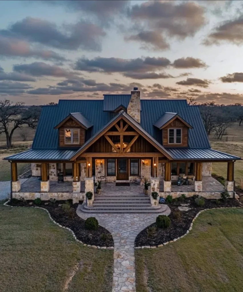 Modern farmhouse with wood columns, stone accents, metal roof, and large front porch.