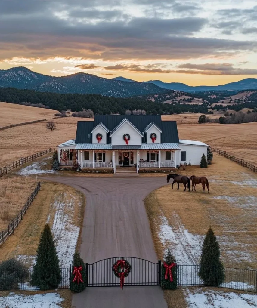 Modern farmhouse decorated for Christmas with mountain views, horses, and gated driveway.