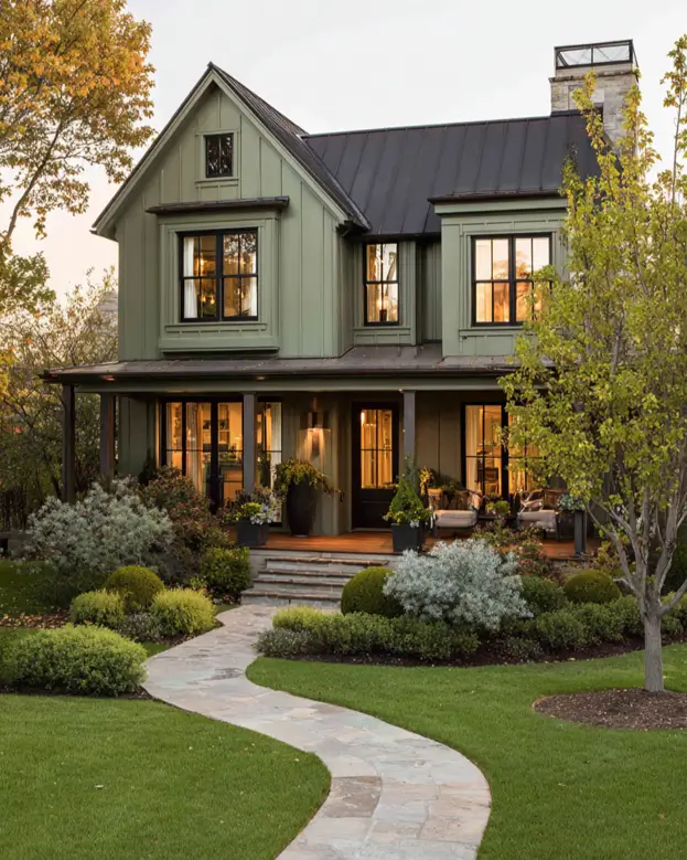 A winding natural stone pathway leading through a garden to the front porch of a modern sage green farmhouse.