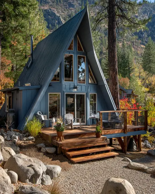 Tiny A-Frame Cabins: 31 Inspiring Ideas for Your Dream Retreat 21 A blue-gray small a frame cabin with muted tones that complement the rocky mountain landscape.